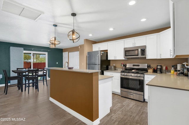 215 E Lester St, Tucson, AZ 85705 - kitchen featuring white cabinets, appliances with stainless steel finishes, light wood-type flooring, visible vents, and a center island with sink