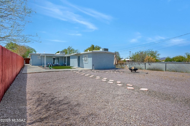 215 E Lester St, Tucson, AZ 85705 - back of property featuring a fenced backyard, an outdoor fire pit, and a patio area