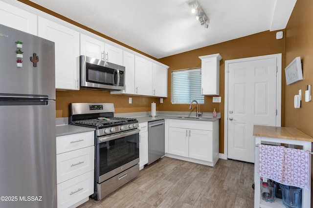 215 E Lester St, Tucson, AZ 85705 - kitchen featuring a sink, light countertops, stainless steel appliances, white cabinetry, and light wood-type flooring