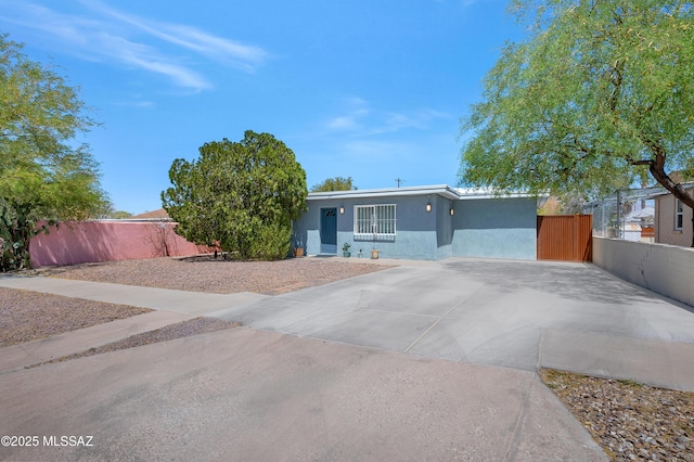 215 E Lester St, Tucson, AZ 85705 - view of front of home featuring fence, stucco siding, and concrete driveway