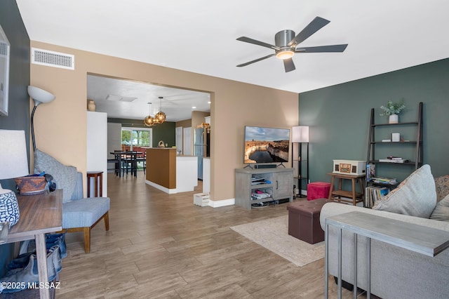 215 E Lester St, Tucson, AZ 85705 - living area featuring visible vents, light wood finished floors, ceiling fan with notable chandelier, and baseboards