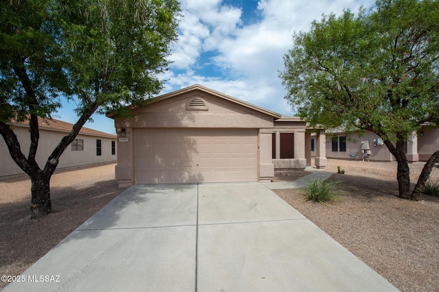 ranch-style home featuring a garage, stucco siding, and driveway