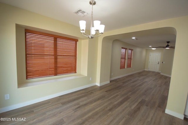 unfurnished room featuring arched walkways, ceiling fan with notable chandelier, baseboards, wood finished floors, and visible vents