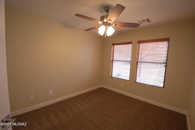 empty room with a ceiling fan, baseboards, visible vents, and dark colored carpet