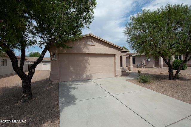 single story home with stucco siding, an attached garage, and driveway