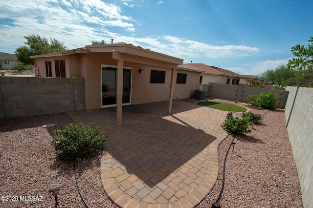 rear view of house featuring central AC, a fenced backyard, a patio area, and stucco siding