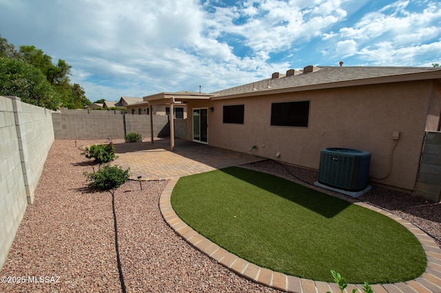 view of yard with a fenced backyard, central AC unit, and a patio area