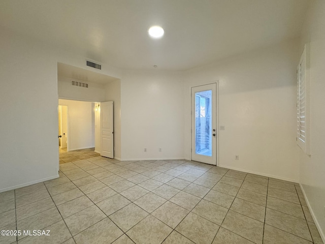 spare room with baseboards, visible vents, and light tile patterned floors