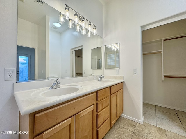 bathroom with a sink, tile patterned flooring, double vanity, and visible vents