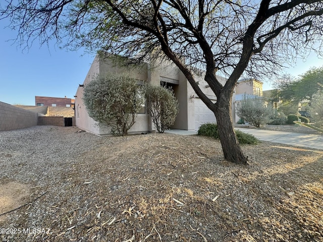 view of property exterior featuring fence and stucco siding