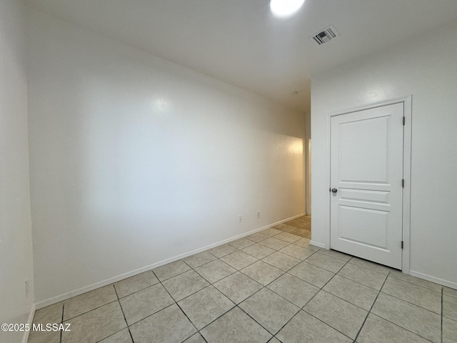 spare room featuring baseboards, light tile patterned floors, and visible vents