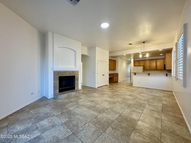 unfurnished living room with baseboards, a fireplace, recessed lighting, and visible vents