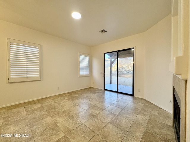 unfurnished living room with visible vents, baseboards, and a fireplace