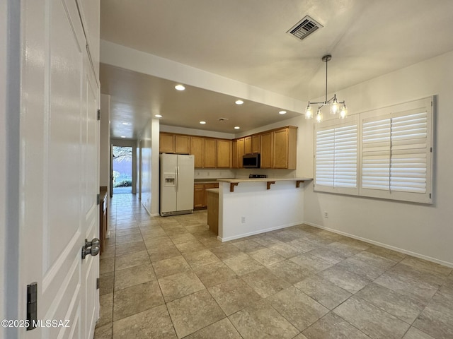 kitchen featuring visible vents, a peninsula, recessed lighting, stainless steel microwave, and white fridge with ice dispenser