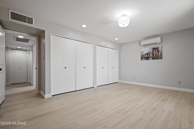 7571 N Rae Ave, Tucson, AZ 85741 - unfurnished bedroom with a wall mounted AC, multiple closets, baseboards, and recessed lighting