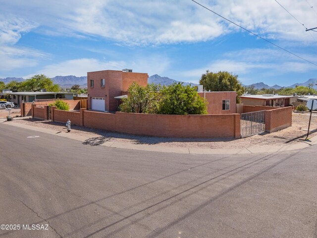 7571 N Rae Ave, Tucson, AZ 85741 - view of front of home with a mountain view, a fenced front yard, a gate, and stucco siding
