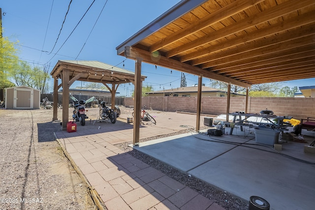 view of patio / terrace with a gazebo, a fenced backyard, a shed, and an outdoor structure