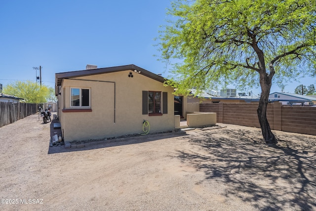 exterior space featuring a fenced backyard and stucco siding