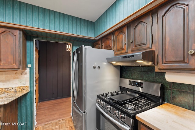 1011 N Placita Yoas, Green Valley, AZ 85614 - kitchen featuring appliances with stainless steel finishes, under cabinet range hood, backsplash, wallpapered walls, and dark brown cabinets