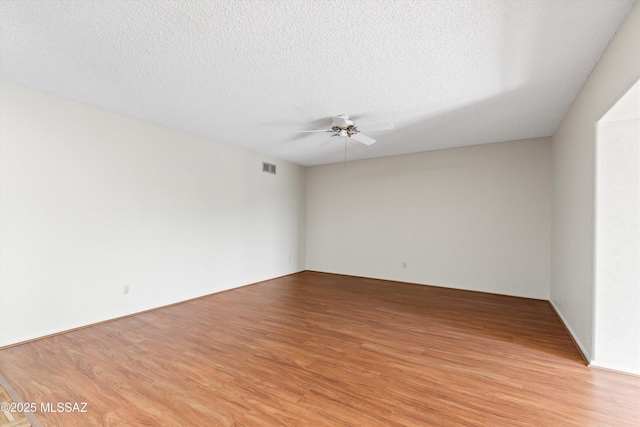 1011 N Placita Yoas, Green Valley, AZ 85614 - empty room with light wood-style floors, a ceiling fan, and a textured ceiling