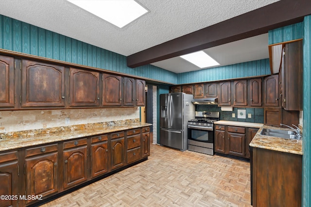 1011 N Placita Yoas, Green Valley, AZ 85614 - kitchen featuring appliances with stainless steel finishes, under cabinet range hood, a sink, dark brown cabinets, and a textured ceiling