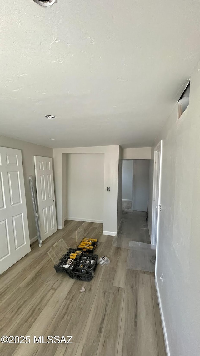 hallway with baseboards and wood finished floors