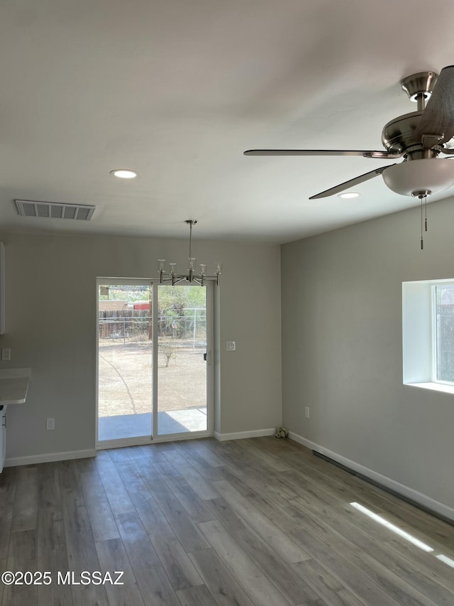 3923 E 17th St, Tucson, AZ 85711 - empty room featuring baseboards, a ceiling fan, recessed lighting, wood finished floors, and a chandelier