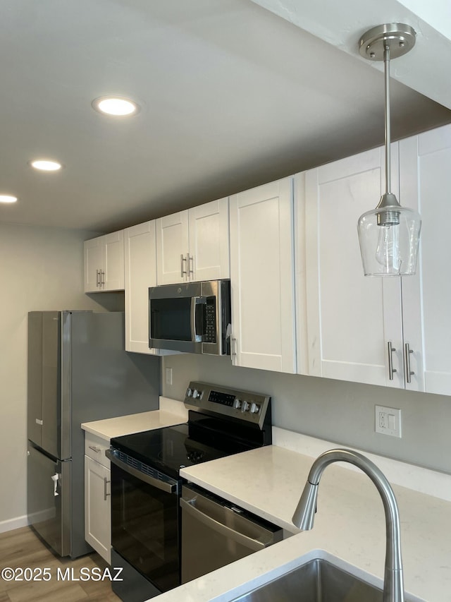 3923 E 17th St, Tucson, AZ 85711 - kitchen featuring stainless steel appliances, light countertops, white cabinets, and recessed lighting