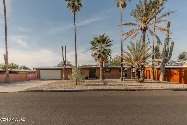 5417 E 3rd St, Tucson, AZ 85711 - view of front facade featuring fence, an attached garage, driveway, and brick siding