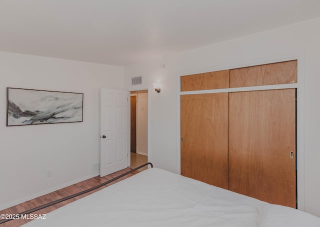 5417 E 3rd St, Tucson, AZ 85711 - bedroom with visible vents, baseboards, wood finished floors, and a closet
