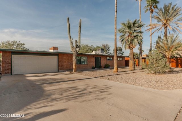 5417 E 3rd St, Tucson, AZ 85711 - view of front facade with brick siding, an attached garage, and concrete driveway
