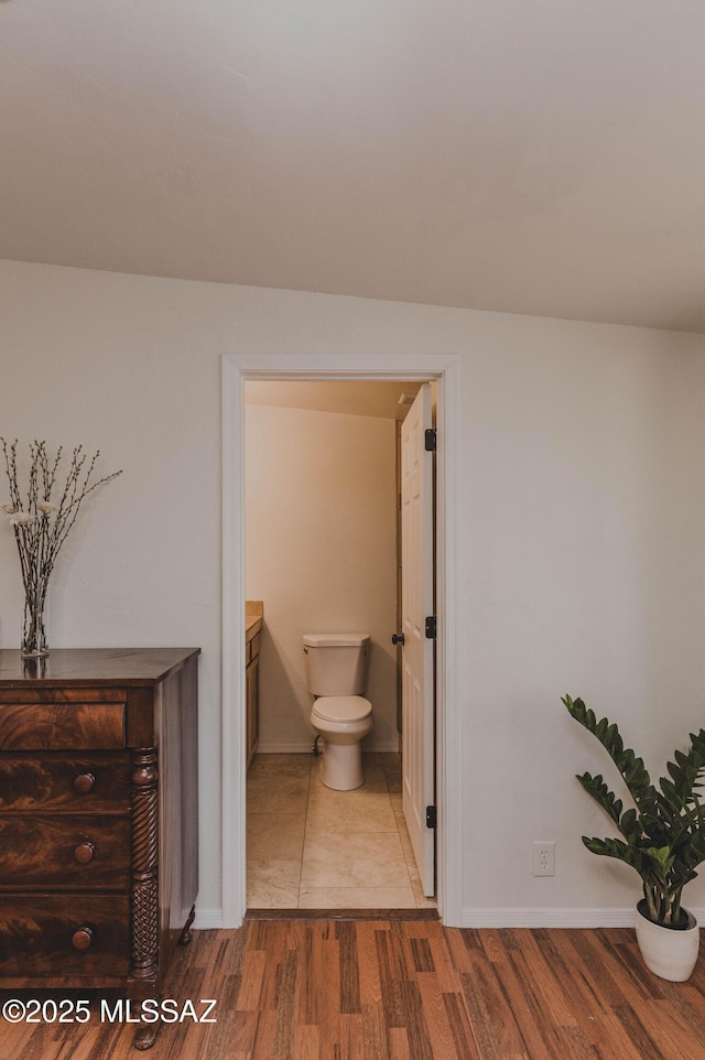 5417 E 3rd St, Tucson, AZ 85711 - bathroom with baseboards, toilet, and wood finished floors