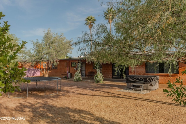 5417 E 3rd St, Tucson, AZ 85711 - rear view of house featuring brick siding and a trampoline