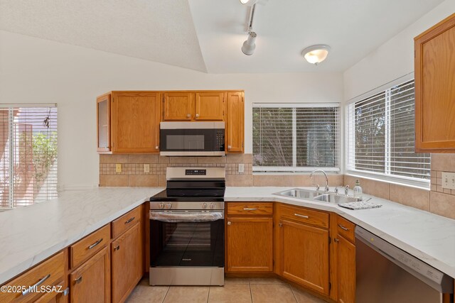 3564 W Sky Ridge Loop, Tucson, AZ 85742 - kitchen with appliances with stainless steel finishes, a peninsula, light countertops, backsplash, and light tile patterned flooring