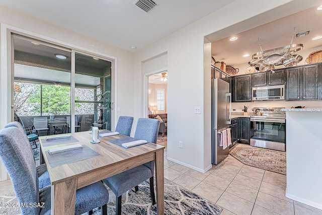 dining area featuring light tile patterned floors, baseboards, plenty of natural light, and visible vents