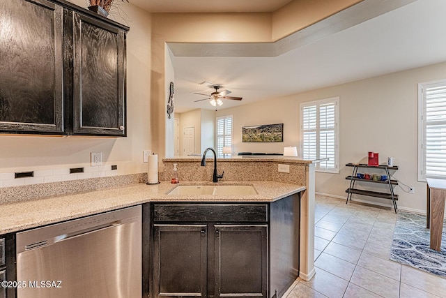 kitchen featuring ceiling fan, stainless steel dishwasher, a sink, a peninsula, and light tile patterned flooring