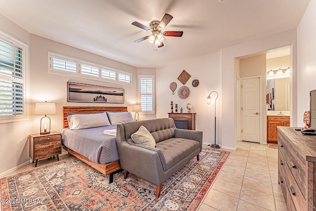 bedroom featuring baseboards, ensuite bathroom, a ceiling fan, and light tile patterned flooring