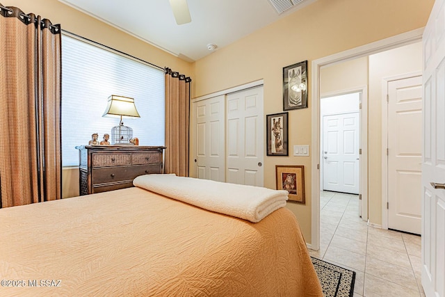 bedroom featuring ceiling fan, a closet, light tile patterned flooring, and visible vents