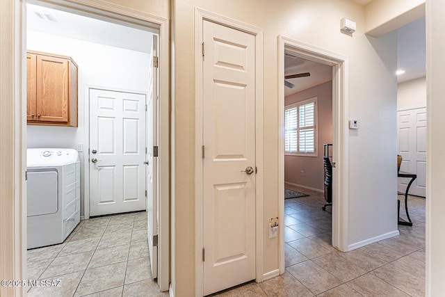 corridor featuring baseboards, washer / dryer, and light tile patterned floors