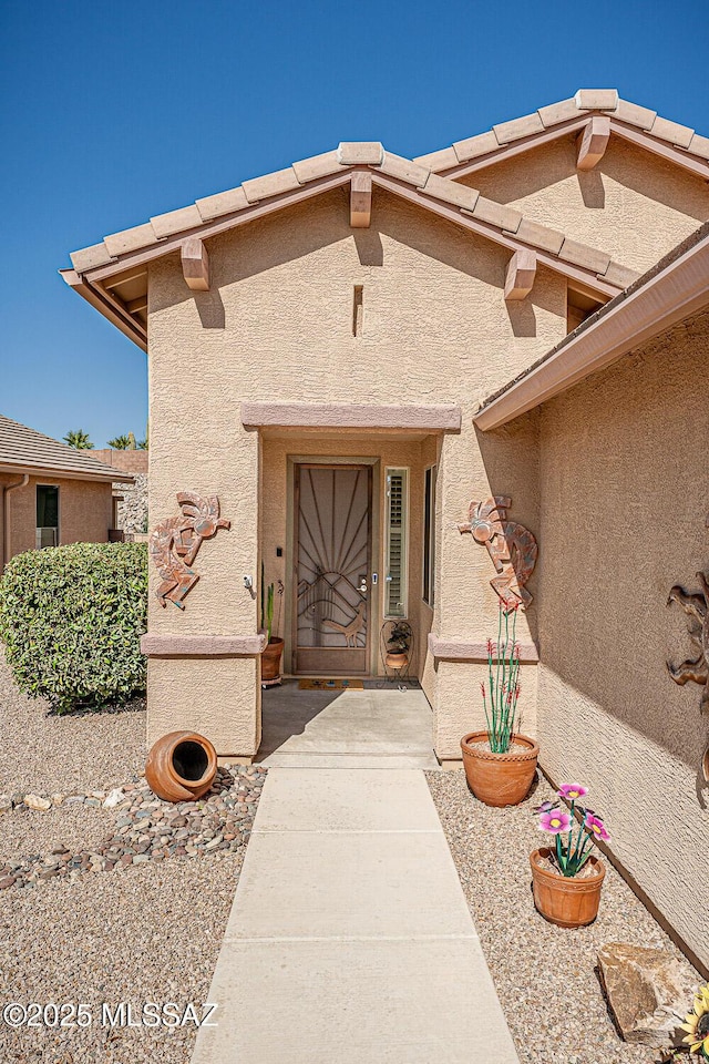 doorway to property featuring stucco siding