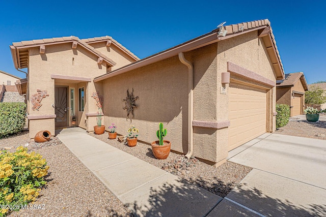 view of front of property with a garage, stucco siding, and driveway