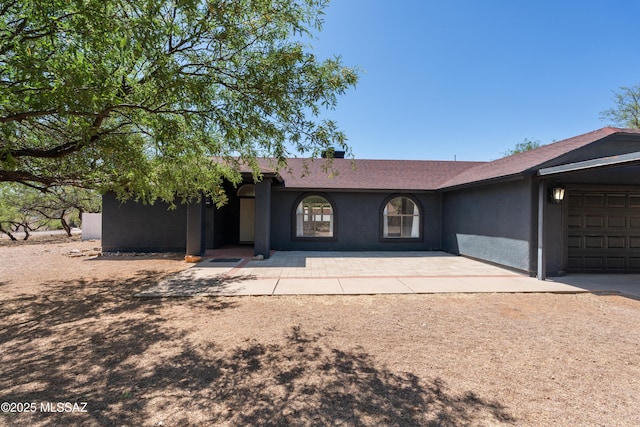 ranch-style home with a garage and stucco siding