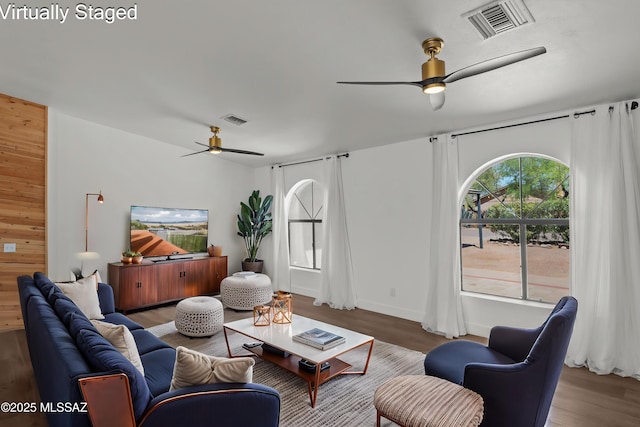 living room with visible vents, a ceiling fan, and wood finished floors
