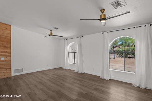spare room featuring ceiling fan, wood finished floors, and visible vents