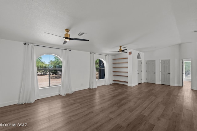 unfurnished living room featuring visible vents, ceiling fan, wood finished floors, and a wealth of natural light