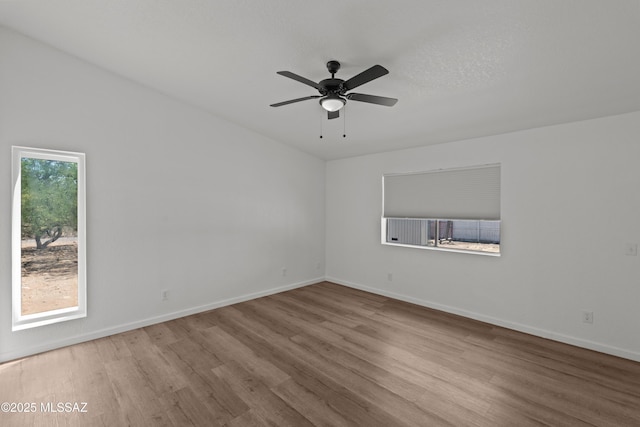 spare room with baseboards, a ceiling fan, and wood finished floors