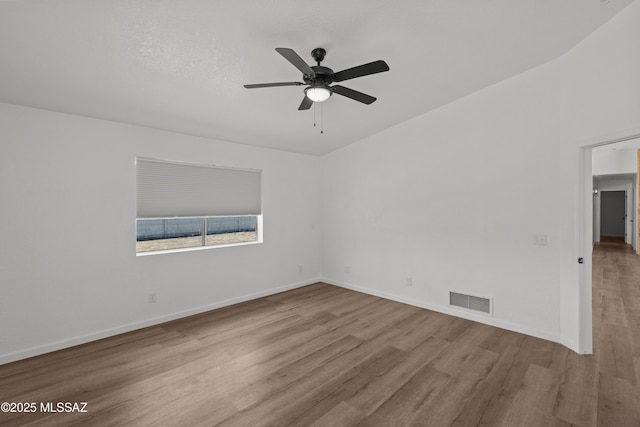 unfurnished room featuring baseboards, ceiling fan, visible vents, and wood finished floors