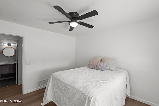 bedroom featuring a sink, baseboards, wood finished floors, and visible vents