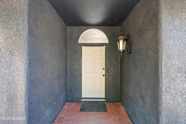 doorway to property featuring stucco siding
