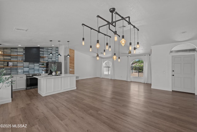 unfurnished living room with a textured ceiling and wood finished floors
